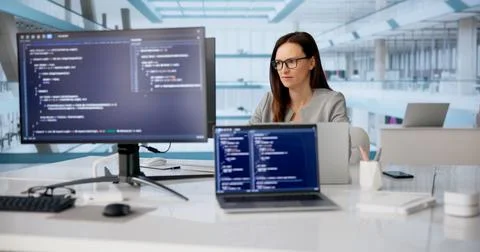 Cheerful Woman Developer Coding On Laptop In Modern Workspace Stockfoto's