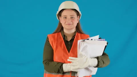 Cheerful woman engineer holds stack of papers on blue Stock Footage 316116164
