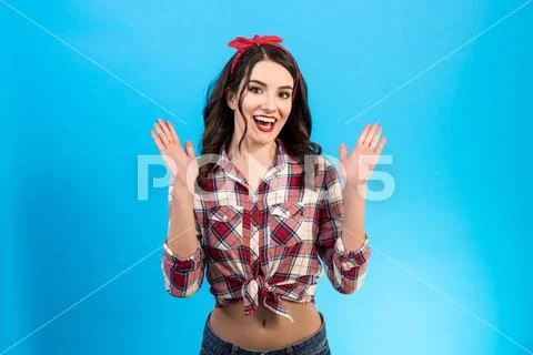 The cheerful woman gesturing on the blue background Stock Photos