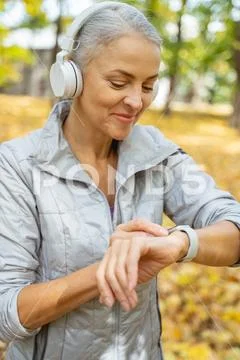Cheerful woman looking at her fitness gadget Stock Photos