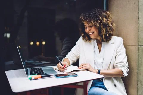 Cheerful woman making notes while preparing to university exams Stock Photos