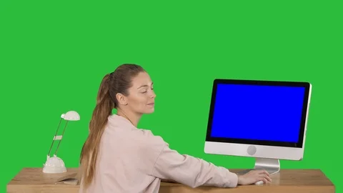Cheerful woman sitting at the table with a computer in office and looking at Stock-Footage 108116783
