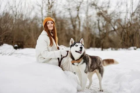 Cheerful woman in the snow playing with a dog outdoors friendship winter Stock Photos