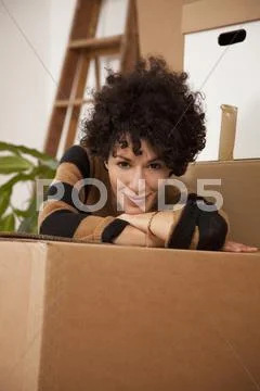 A cheerful woman taking a coffee break while moving house Stock Photos