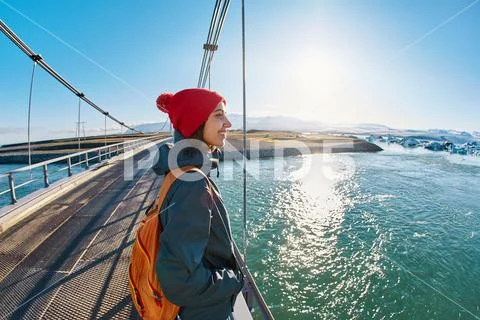 Cheerful woman walks on the brige in Jokulsarlon Ice Lagoon Stock Photos