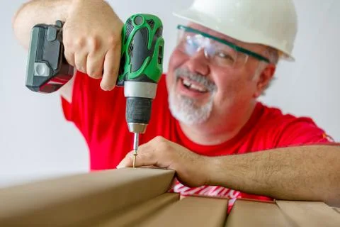 Cheerful worker assembling wood with drill-drive Stock Photos