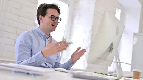Cheerful Working Young Man doing Video Chat on Laptop Stock Photos