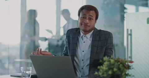 Cheerful young african employee using laptop computer and shrugging shoulders to Stock Footage 150113803