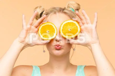 Cheerful young blonde posing with fresh oranges Stock Photos