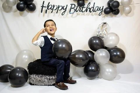 Cheerful Young Boy Posing With Balloon Decoration At Indoor Birthday Party Stock Photos