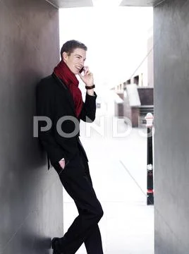 A cheerful young businessman receiving good news via his smart phone Stock Photos