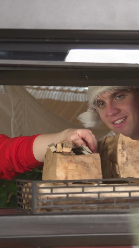 Cheerful young couple is loading firewood to light a fireplace on Christmas Eve Stock Footage 291348960