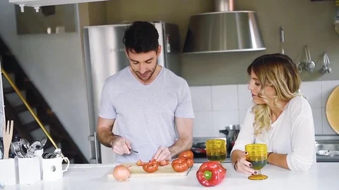 Cheerful young couple sitting at kitchen together and cooking Stock Footage 74728550