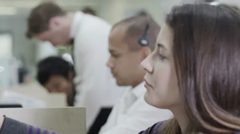 Cheerful young customer service operator, at work in a busy call center Stock Footage 25757472
