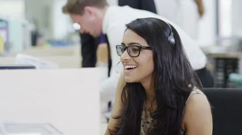 Cheerful young customer service operator, at work in a busy call center Stock Footage