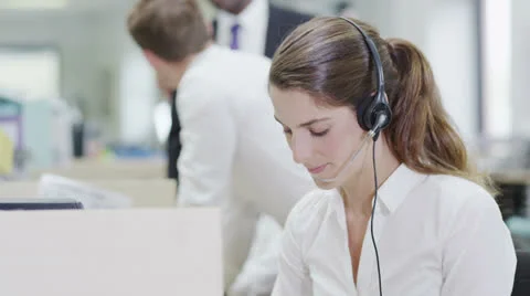 Cheerful young customer service operator, at work in a busy call center Stock Footage 25773509