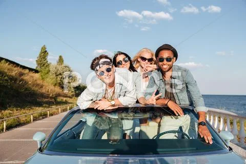 Cheerful young friends driving car in summer Stock Photos