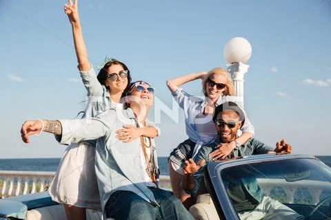 Cheerful young friends sitting and relaxing in car Stock Photos