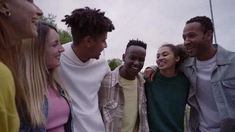 Cheerful young group multi-ethnic friends hugging enjoying spring day outdoors Stock Footage 252086871