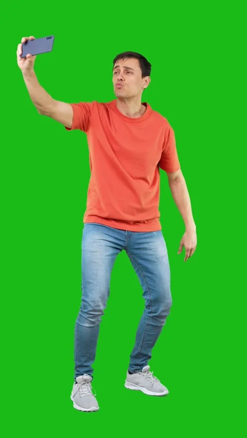 Cheerful young guy taking selfie on smartphone isolated on green background Vídeos de archivo 246270153