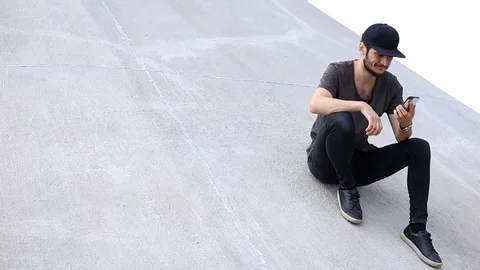 Cheerful young guy use smartphone. Dressed in black. Stock Footage 115737085