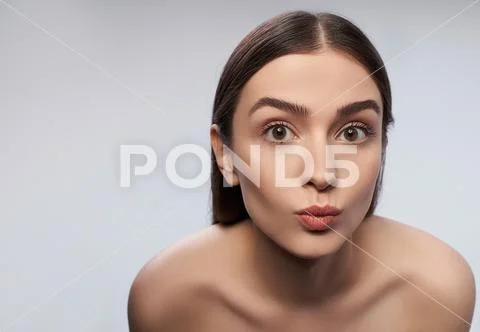 Cheerful young lady with natural makeup pouting lips Stock Photos