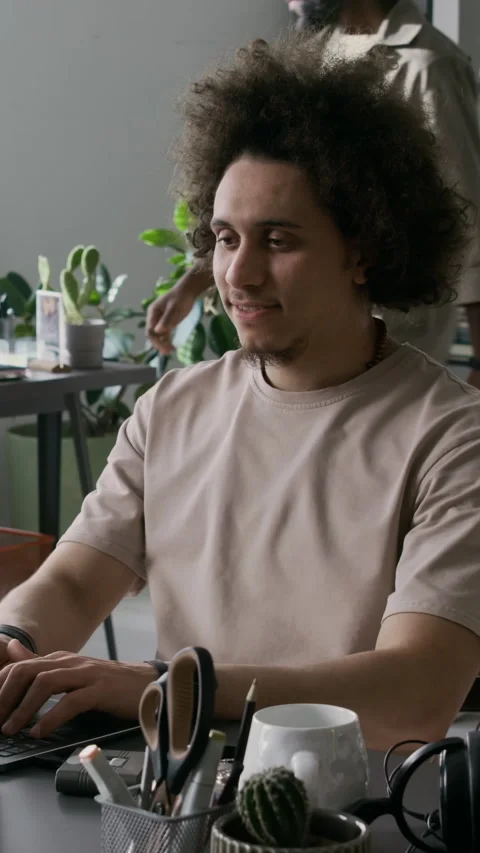 Cheerful Young Male Software Developer Working on Laptop at Office Desk Stock Footage 299198355