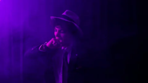 Cheerful young man in black suit and hat talks and moves his body drunk danci Stock Footage 230226845