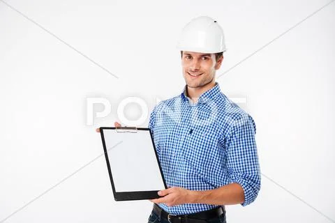 Cheerful young man builder in building helmet holding blank clipboard Stock Photos