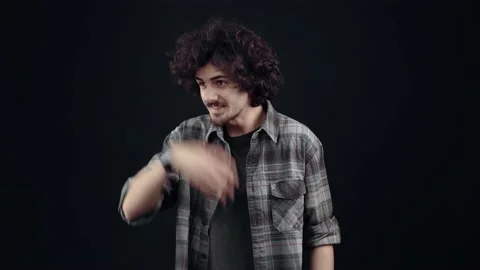 Cheerful young man greets sideways with his hand, and smiling. Hipster in a Video stock 150311118