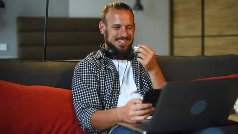 Cheerful young man having a video call using his laptop at home. Stock Footage 136548254