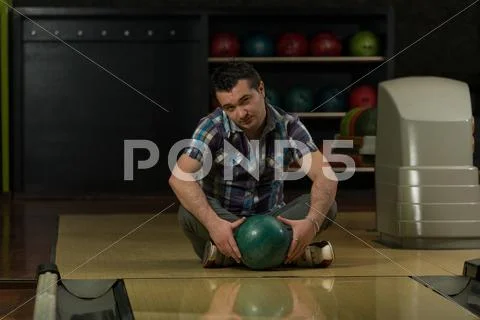 Cheerful young man holding bowling ball Stock Photos
