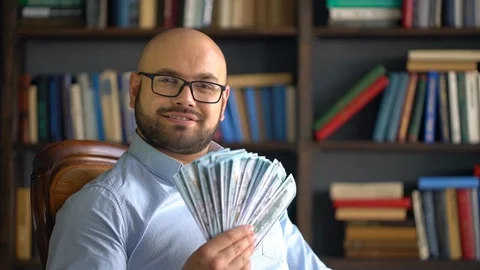 Cheerful young man making a fan of money and waving them Stock Footage 86801649