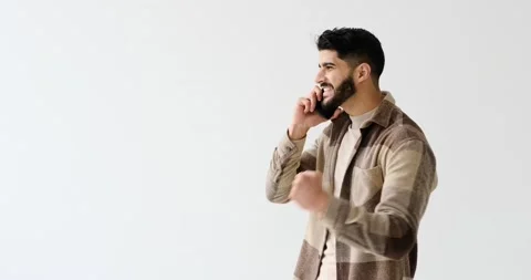 Cheerful young man talking on mobile phone Stock Footage 196076562