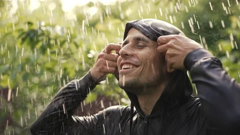 Cheerful young man under rain Stock Footage 155997601