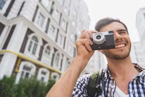 Cheerful young man using camera by travel Foto stock