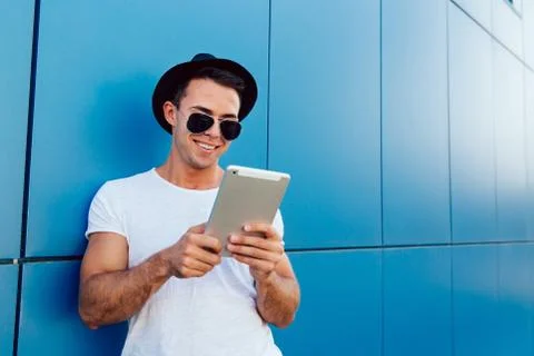 Cheerful young man using a tablet computer, outdoors Stock Photos