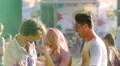 Cheerful young men and woman having fun at concert, friends colored with powder HD Footage