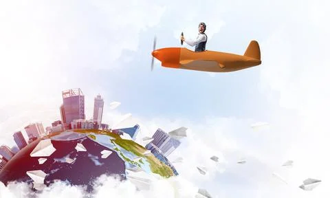 Cheerful young pilot sitting in cabin Stock Photos