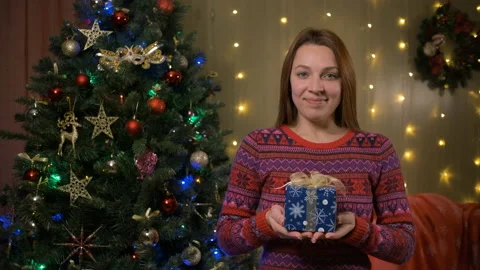 Cheerful young woman offering gift box to camera and smiling. Christmas concept Stock Footage 166461853