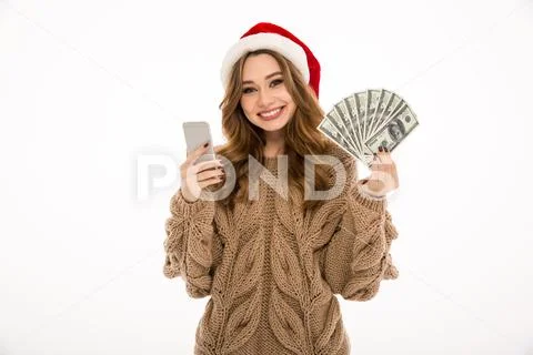 Cheerful young woman using mobile phone holding money. Stock-Fotos