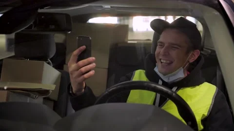 Cheerfull delivery man in car making conference call with his child during his Stock Footage 144133503