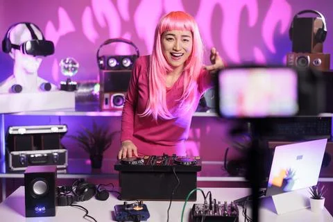 Cheerfull dj performing eletronic song at professional mixer console while Stock Photos