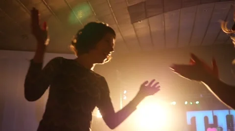 Cheerfully dancing jumping hands in air female fans at the concert Stock Footage 48731987