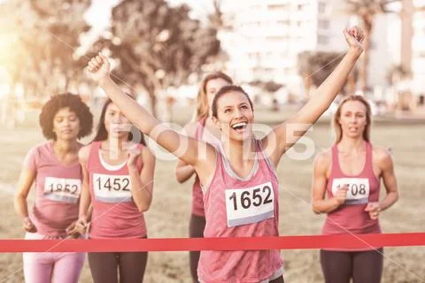 Cheering brunette winning breast cancer marathon Stock Photos