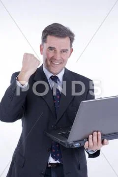 Cheering businessman, 50+, with a laptop Stock Photos