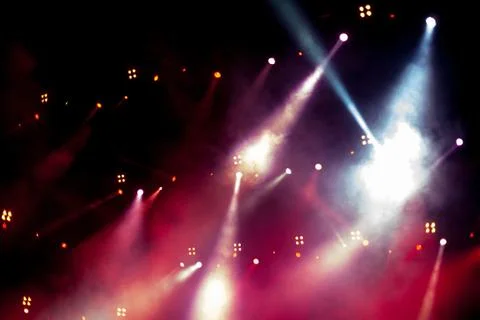 Cheering crowd in front of bright stage lights Stock Photos