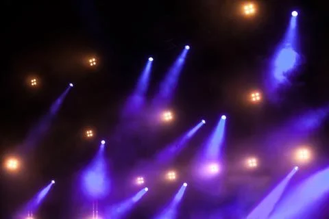 Cheering crowd in front of bright stage lights Stock Photos