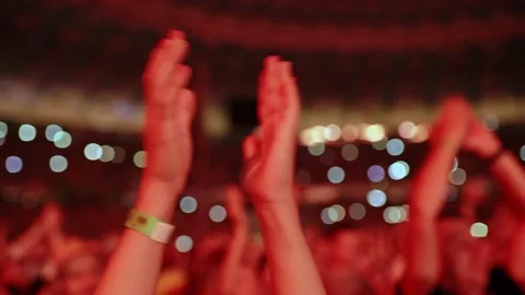 Cheering hands at a concert in front of a large stage in the spotlight close-up Stock Footage 224725499