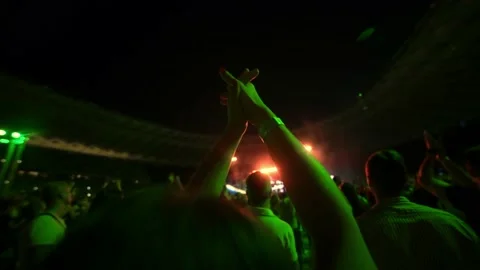Cheering hands at a concert in front of a large stage in the spotlight close-up Stock Footage 237465379